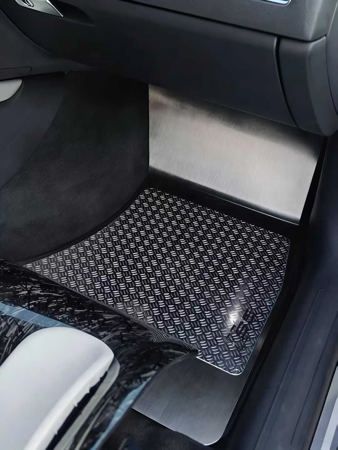 Actual custom metal floor mat fitted in a clean black passenger footwell
