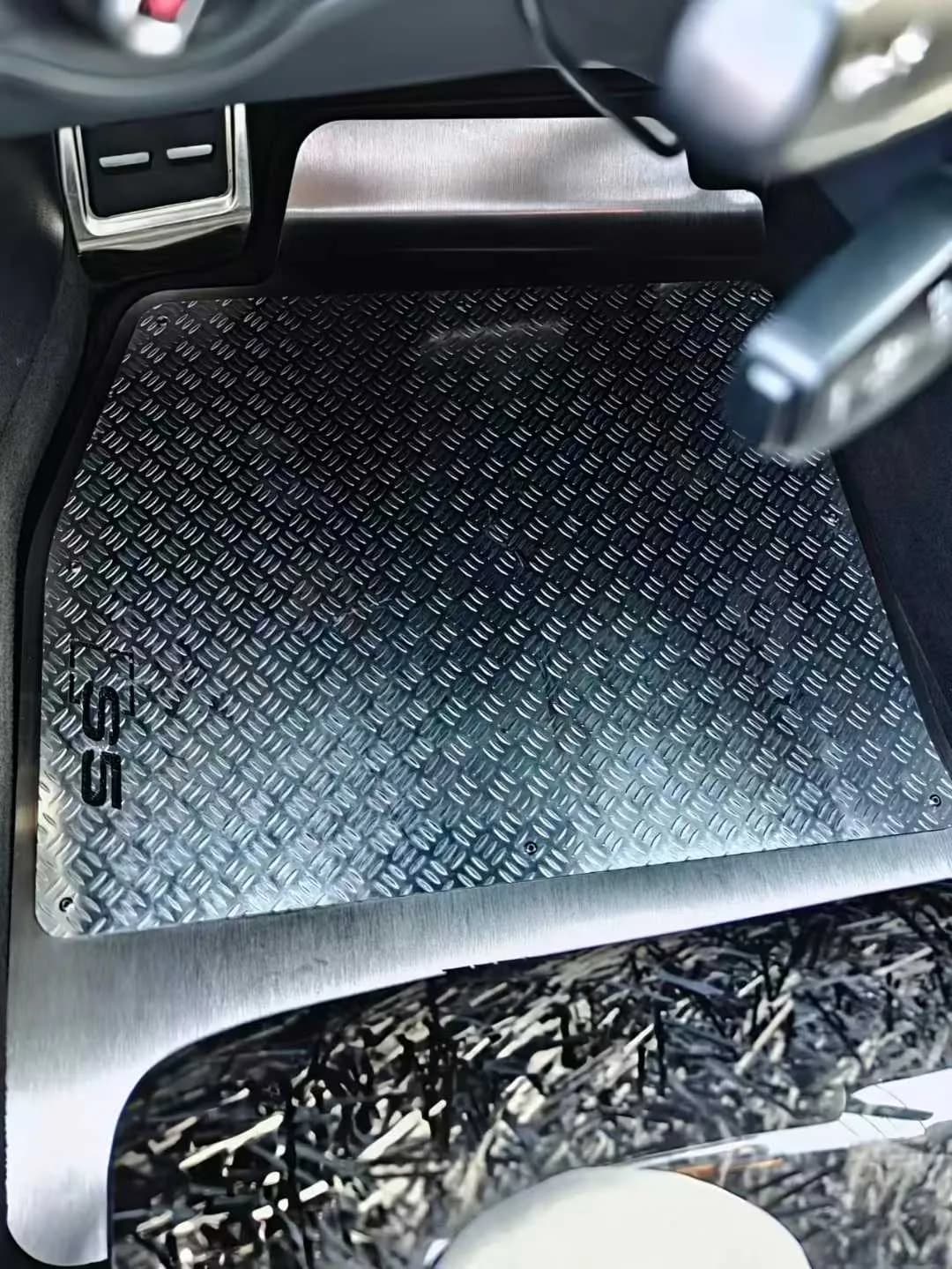 Actual diamond-pattern metal floor panel installed in a black car interior