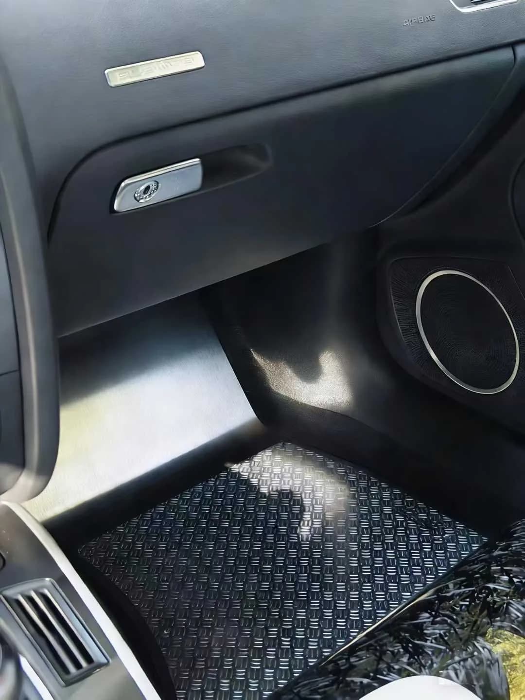 Actual brushed metal passenger floor panel in a black daily-use cabin