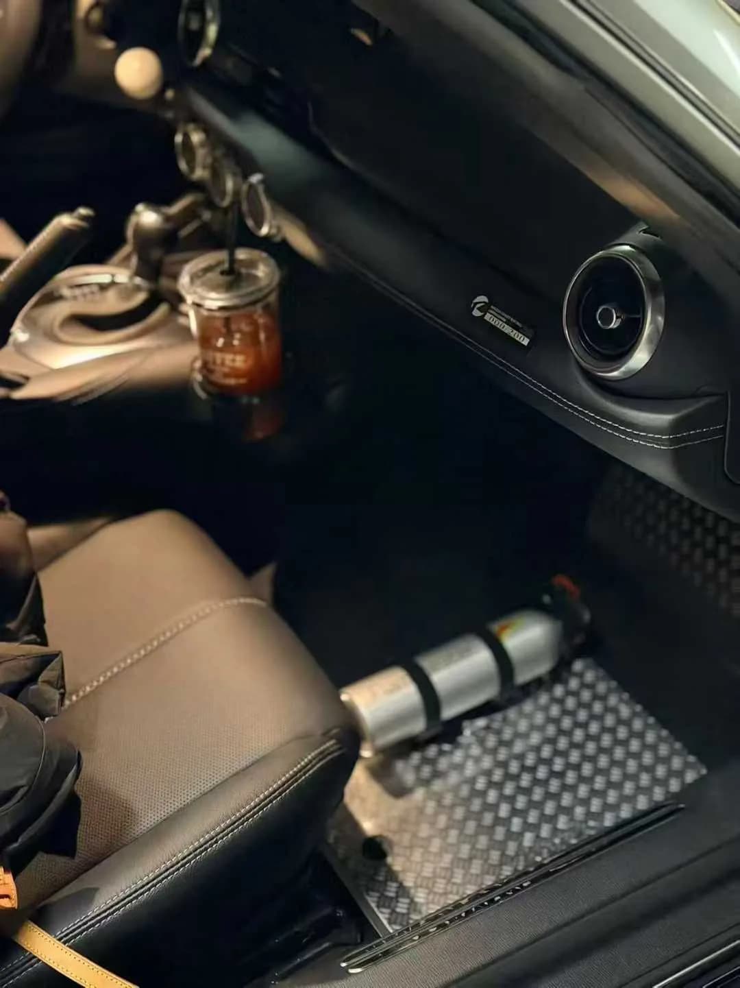 Actual perforated metal car floor mat installed in a dark passenger cabin