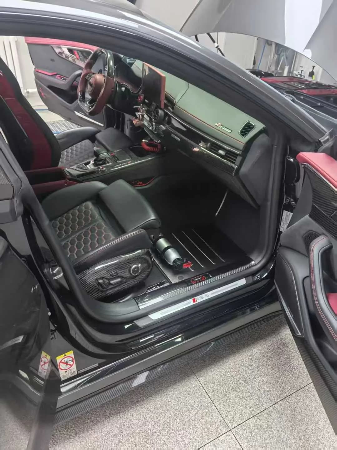 Actual front metal floor mat set installed in a dark sport-oriented interior